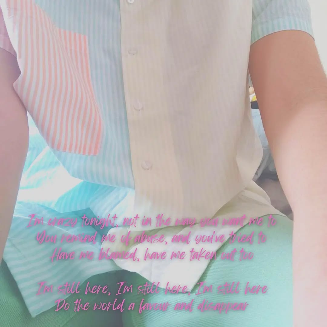 A zoomed-in faded, over-exposed picture of someone wearing a blue, yellow and pink shirt, with green trousers.

In cursive pink letters, a poem reads:
"I'm crazy tonight, not in the way you want me to
You remind me of abuse, and you've tried to
Have me blamed, have me taken out too

I'm still here, I'm still here, I'm still here
Do the world a favour and disappear"